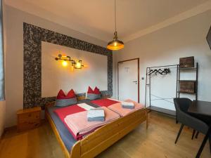 a bedroom with a bed with red pillows on it at Hotel Mühlental in Wernigerode