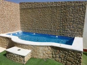 una piscina en la esquina de una pared de piedra en Apartamentos la Fuente en Córdoba