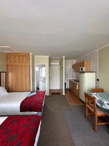Una habitación de hotel con dos camas y cocina. en Apart hotel Terra Valdivia, en Valdivia