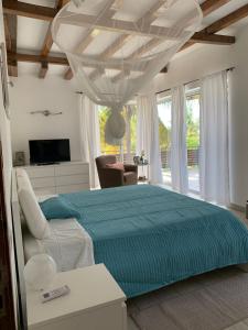 1 dormitorio con 1 cama grande con manta azul en CASA MOZITA en Vilanculos