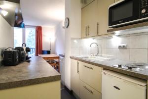 a kitchen with a sink and a microwave at Spacious Apartment Iris, Flaine Foret in Flaine