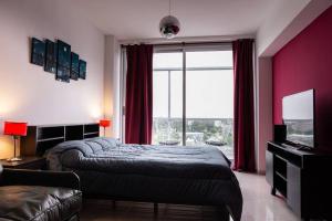 a bedroom with two beds and a large window at Libertador 6430 by depptö in Buenos Aires