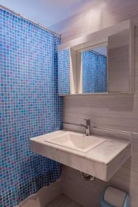 a bathroom with a sink and a blue tiled wall at Libertador 6430 by depptö in Buenos Aires