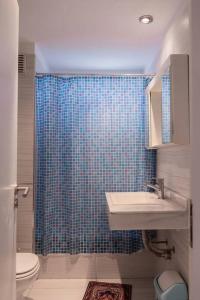 a bathroom with a sink and a blue shower curtain at Libertador 6430 by depptö in Buenos Aires