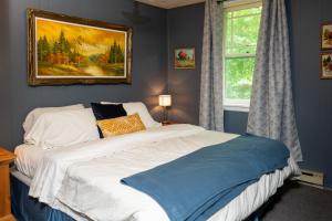 a bedroom with a bed with a painting on the wall at Cobblestone Cottages in Sharbot Lake