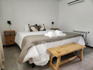 a bedroom with a bed and a wooden table at CABRAL CENTRO in Rafaela