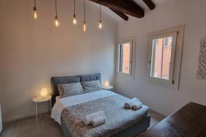 a bedroom with a bed and two windows at S. GIACOMO DA L'ORIO in Venice