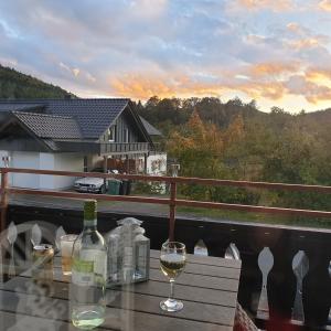 una copa de vino sentada en una mesa en un balcón en Gemütlicher Ferienwohnung in Niedersfeld bei Winterberg, kostenloses WLAN, en Winterberg