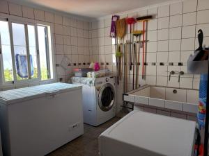 a kitchen with a washing machine and a sink at Peaceful place in Porto Moniz in Salão