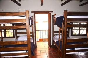 a room with three bunk beds and a doorway at Ríos Voladores Hostel in Bogotá