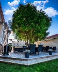 a table and chairs under a tree in a yard at Hotell Hertig Karl in Filipstad