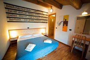 a bedroom with a blue bed with two towels on it at Agriturismo Campo Rosso in Civitella di Romagna