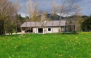 uma velha casa de pedra num campo de flores em Le Refuge de Jorance et son spa privatif 5 places en pleine nature em Saint-Julien-du-Pinet