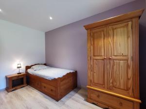 um quarto com uma cama e um armário de madeira em Le Refuge de Jorance et son spa privatif 5 places en pleine nature em Saint-Julien-du-Pinet