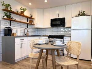 una cucina con tavolo, sedie e frigorifero bianco di The Cozy Oasis - A Renovated and Modern Studio near LAX + SoFi + Beaches + Freeway a Lawndale