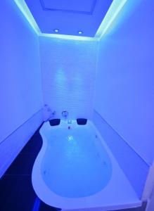a white bath tub in a room with blue lights at Jordan luxury suite in Eilat