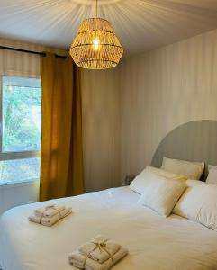 1 dormitorio con 1 cama grande y toallas. en Gîte Ethic Simple & Chic, en Labastide-Marnhac