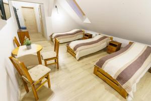 a room with three beds and a table and chairs at Zakole Wiaru in Wojtkowa