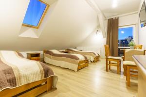a room with three beds and a window at Zakole Wiaru in Wojtkowa