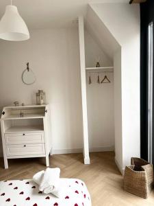 um quarto branco com uma cama e uma cómoda em Cocon d'Alsace em Colmar