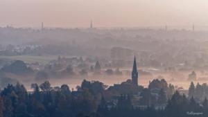 a foggy city with a church and a town in the background at Berggasthof Koitsche im Naturpark Zittauer Gebirge in Bertsdorf