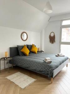 um quarto com uma cama com almofadas amarelas e um espelho em Cocon d'Alsace em Colmar