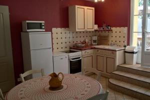 - une petite cuisine avec une table et un vase dans l'établissement Gîte La Charlette, à Cheval-Blanc