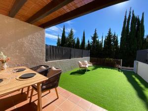 une terrasse avec une pelouse dotée d'une table et de chaises. dans l'établissement Kalma House, à Torroella de Montgrí