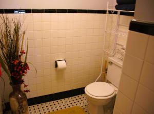 a bathroom with a toilet and a vase with flowers at Private Lakeview Cottage and 2 Farmhouse Apartments near Rt 80 easy to NYC in Blairstown +57 photos