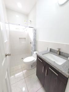 a white bathroom with a sink and a toilet at Casa Perla ¡Clima y Comfort! in El Rosario