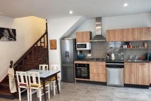 a kitchen with a table and a kitchen with a staircase at Gîte L'atelier de la Rivière in Belle-Isle-en-Terre