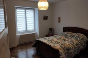 a bedroom with a bed and a window at LAtelier de la Rivière in Belle-Isle-en-Terre