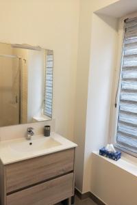 a bathroom with a sink and a mirror at LAtelier de la Rivière in Belle-Isle-en-Terre