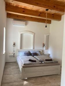 Un dormitorio con una cama grande en una habitación con techos de madera. en Mezriczky Malom Kapolcs, en Kapolcs