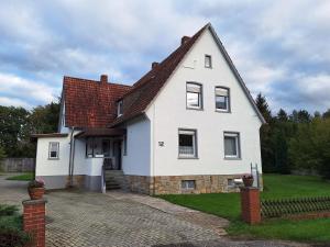 uma casa branca com um telhado vermelho e uma entrada em Schlafen vor den Toren von Osnabrück für 5 Pers. 