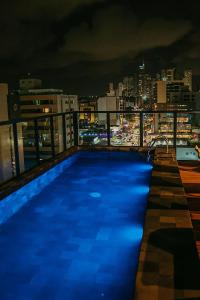 una piscina in cima a un edificio di notte di Urban by Hosppedar a Tambaú
