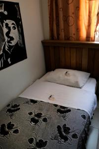 a bedroom with a bed with a black and white blanket at Hostal Chorro De Quevedo in Bogotá