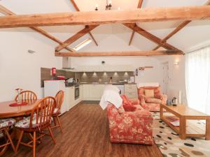a kitchen and a living room with a table and chairs at Poppy Cottage in Cowbridge