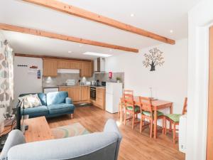 a kitchen and living room with a couch and a table at Ash Tree Cottage in Cowbridge