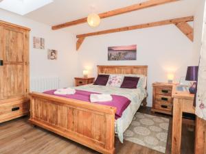sypialnia z drewnianym łóżkiem i biurkiem w obiekcie Ash Tree Cottage w mieście Cowbridge