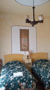 a bedroom with two beds and a chandelier at Hostal La Chacarilla in Copacabana