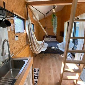 eine Küche und ein Wohnzimmer in einem winzigen Haus in der Unterkunft Ｒ．Ｇａｒｄｅｎ - Vacation STAY 82636v in Yamanakako