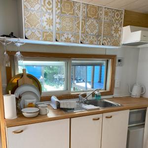 uma cozinha com um lavatório e uma janela em Ｒ．Ｇａｒｄｅｎ - Vacation STAY 10566v em Yamanakako
