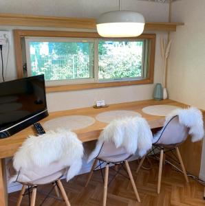 山中湖村にあるＲ．Ｇａｒｄｅｎ - Vacation STAY 10566vの木製テーブルの周りに座る白い羽毛の椅子2脚