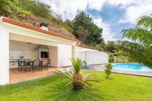a house with a backyard with a swimming pool at Belo Mar in Arco da Calheta