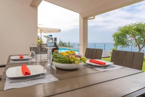 a wooden table with a bowl of fruit on it at Belo Mar in Arco da Calheta