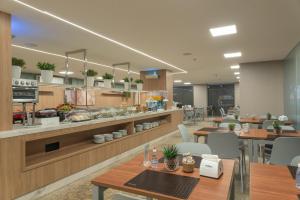 a restaurant with tables and chairs in a cafeteria at Hotel Brisa Tower Maceió in Maceió