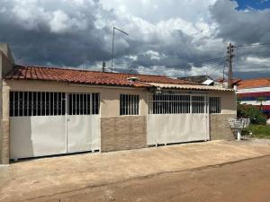 a house with a white fence and a garage at Bela casa, 2 qtos Taguatinga-DF in Brasília