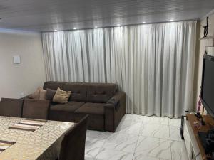 a living room with a couch and a table at Bela casa, 2 qtos Taguatinga-DF in Brasília
