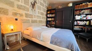 ein Schlafzimmer mit einem Bett und einem Bücherregal in der Unterkunft Chambres d'hôtes Andrea in Brive-la-Gaillarde